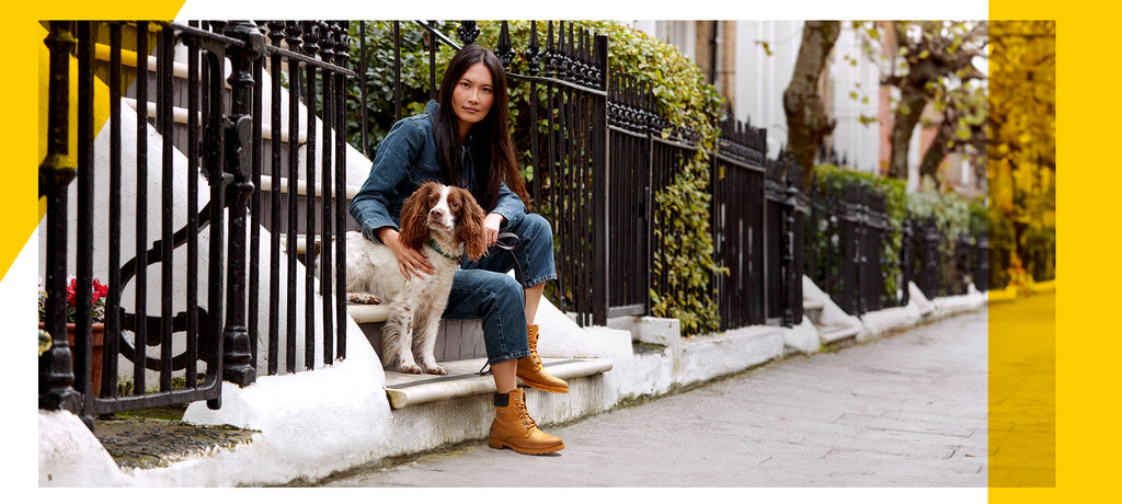 Chica sentada en escalera con perro